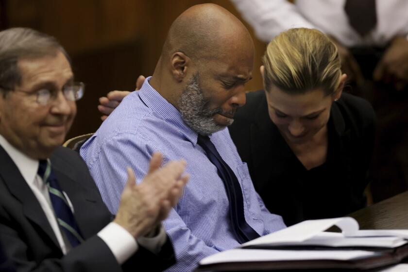Lamar Johnson, center, and his attorneys react on Tuesday, Feb. 14, 2023, after St. Louis Circuit Judge David Mason vacated his murder conviction during a hearing in St. Louis, Mo. Johnson served nearly 28 years of a life sentence for a killing that he has always said he didn't commit. (Christian Gooden/St. Louis Post-Dispatch via AP, Pool)