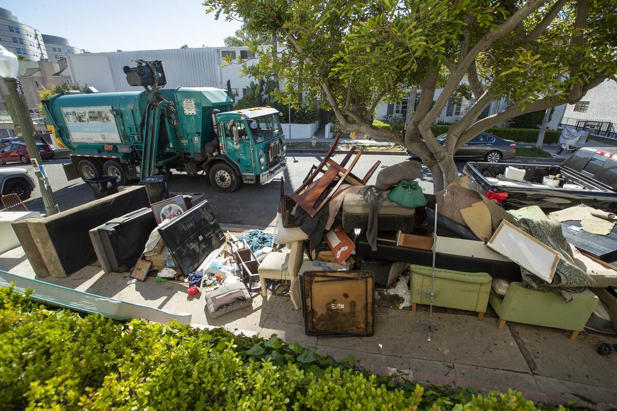 Discarded furniture is piled up outside a private apartment building