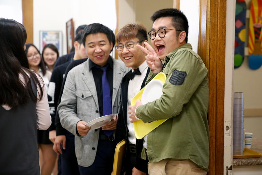 SAN MARINO, CALIF. -- TUESDAY, OCTOBER 18, 2016: Rain Liang, 18, far right, of China, a senior, shown with senior Ping Chen, 19, of Taiwan, to his left, wait in line for luck at the Southwestern Academy, in San Marino, Calif., on Oct. 18, 2016. A growing trend of Chinese national's coming to the U.S. at younger and younger ages, a reflection of growing desperation on the part of Chinese parents to get their kids to U.S. schools. (Gary Coronado / Los Angeles Times)