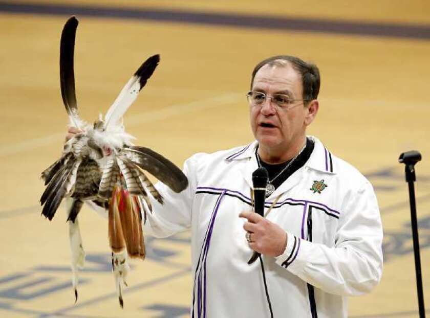 Brian Patterson, a Native American, shows his headdress from the Bear Clan as he speaks to the Newport Harbor High lacrosse players and their families Monday.