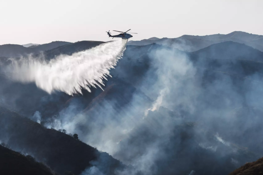 CalFire arroja agua desde un helicóptero 