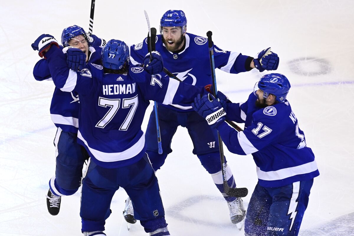 Tampa Bay Lightning defenseman Victor Hedman (77) celebrates his winning goal against the Boston Bruins with teammates Ondrej Palat (18), Patrick Maroon (14) and Alex Killorn (17) during the second overtime period of NHL Stanley Cup Eastern Conference playoff hockey game action in Toronto, Monday, Aug. 31, 2020. (Frank Gunn/The Canadian Press via AP)