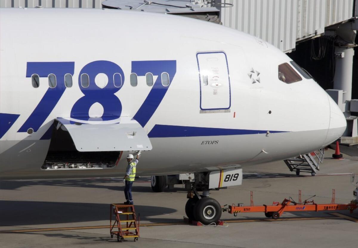 A member of ground staff of All Nippon Airways Co. closes a door near the battery room of a Boeing 787 Dreamliner before departure at Tokyo International Airport.