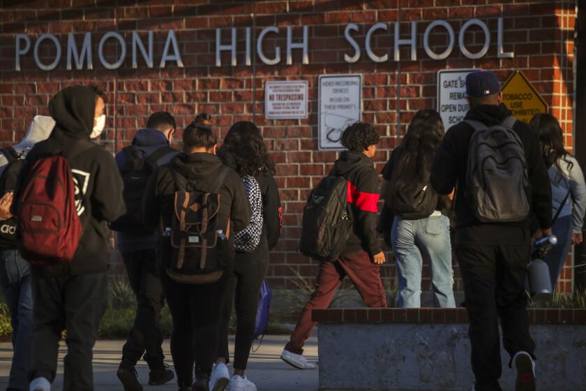 Pomona, CA - November 03: Just four months ago Pomona Unified School District board eliminated police on their high school campuses and replaced them with proctors trained to de-escalate tensions. But shaken by a shooting near a campus the board is bringing back uniformed officers saying that student safety comes first. Students arrive at Pomona High School on Wednesday, Nov. 3, 2021 in Pomona, CA. (Irfan Khan / Los Angeles Times)