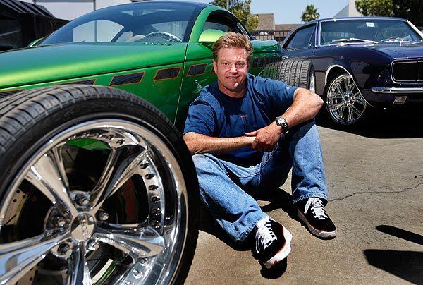 Hot-rod designer Chip Foose sits with his Hemisfear hot rod, with a 1968 Camaro in the background, at Foose Design in Huntington Beach.
