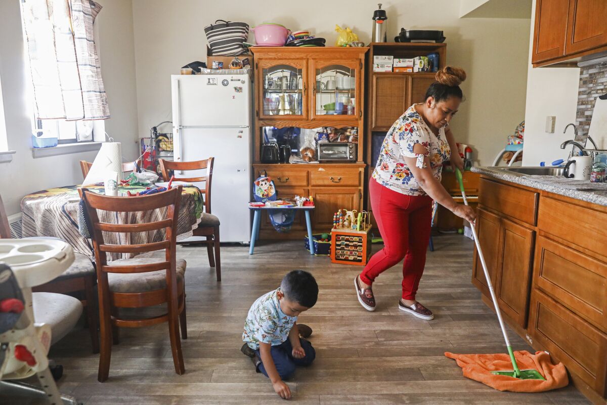 Mirna Arana mops the floor after playing with her three-year-old son Aaron in her home in Oakland, Calif., Oct. 25, 2021. Arana works as a housecleaner in San Francisco and is hopeful about a new plan that would give domestic workers paid sick leave. Domestic workers in San Francisco must be provided paid sick leave under a law approved by the Board of Supervisors this week, Wednesday, Dec. 15. (Brontë Wittpenn/San Francisco Chronicle via AP)