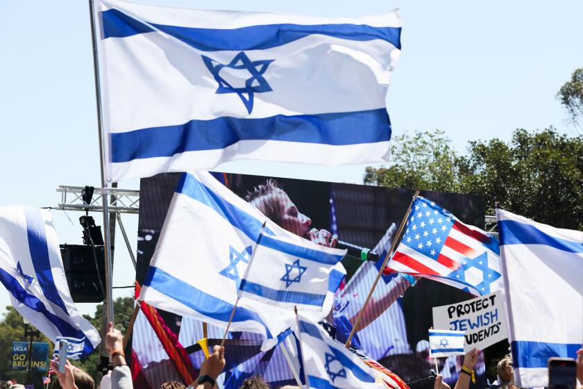 WESTWOOD, CA - APRIL 28: Israeli flags wave in the air during a demonstration in support of Israel at UCLA on Sunday, April 28, 2024 in Westwood, CA. (Robert Gauthier / Los Angeles Times)