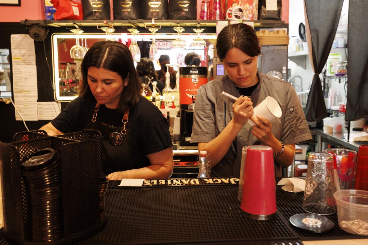 West Hollywood, CA - April 16: Betsy Martinez (left) and Cynthia Temblador (right) prepare coffee at Fan Girl Cafe on Wednesday, April 16, 2025 in West Hollywood, CA. (Carlin Stiehl / Los Angeles Times)