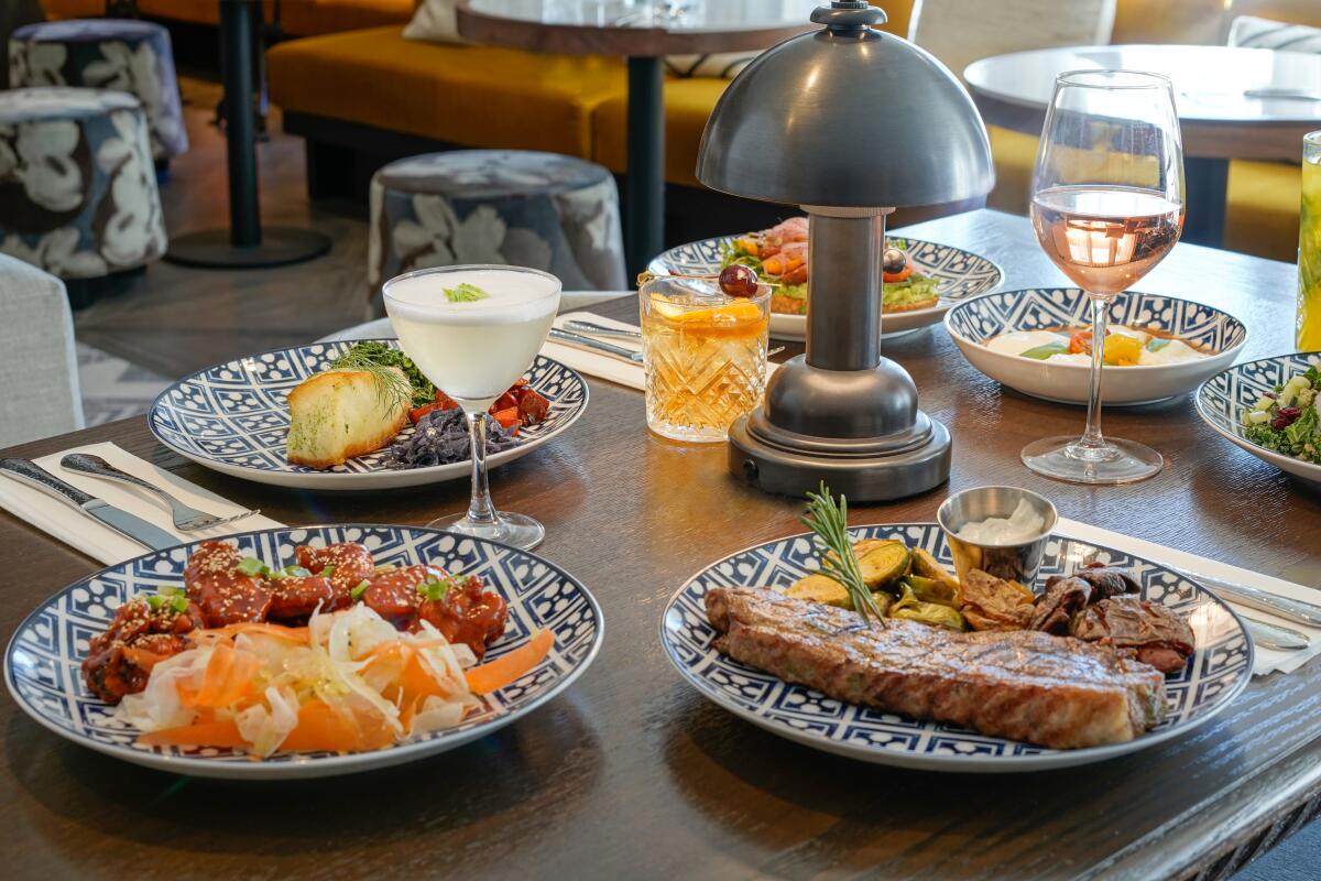 A table with wine glasses and varied dishes including filet mignon