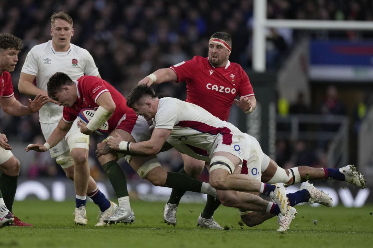 Wales' Taine Basham is caught in possession by England's Courtney Laws and England's Tom Curry during the Six Nations rugby union match between England and Wales at Twickenham stadium, London, Saturday, Feb. 26, 2022. (AP Photo/Alastair Grant)
