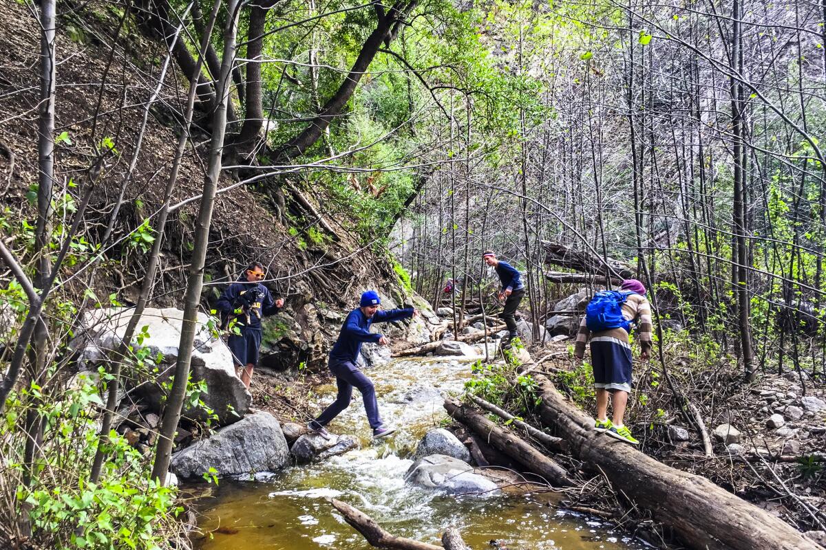 ALTADENA, CA - Hikers crossing the creek at Millard Canyon in the Angeles National Forest.