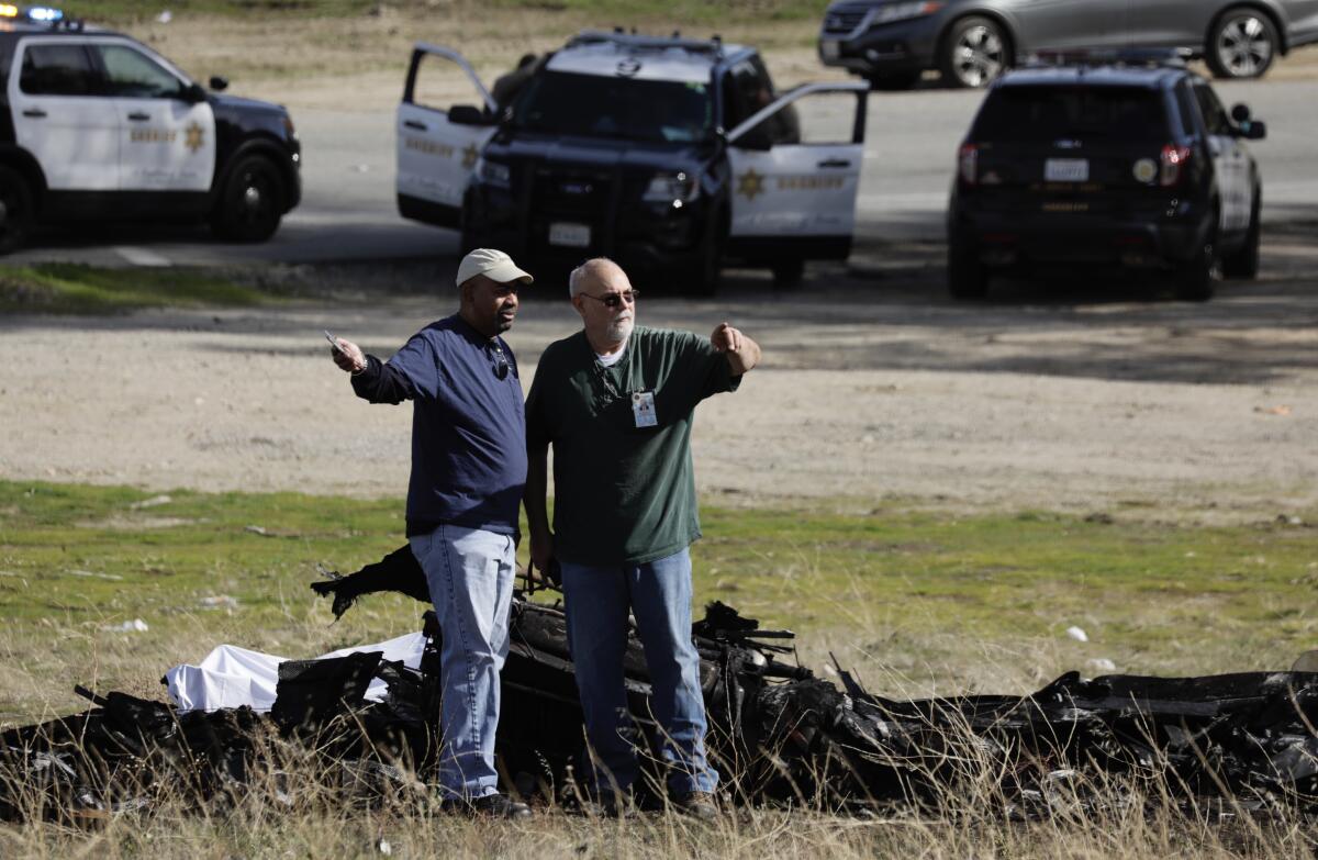 FAA investigators inspect the scene where a single-engine plane crashed Saturday morning near the 14 Freeway in Santa Clarita. The pilot, who was the sole occupant of the aircraft, died.