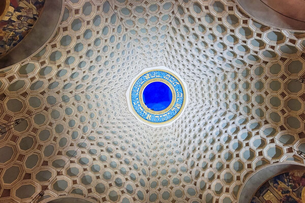 rows of white rings with pale blue centers are clustered around a brilliant blue glass medallion. 