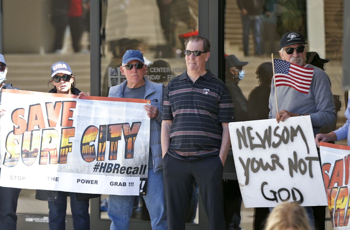 Supporters stand by during a press conference at Huntington Beach City Hall on Thursday.