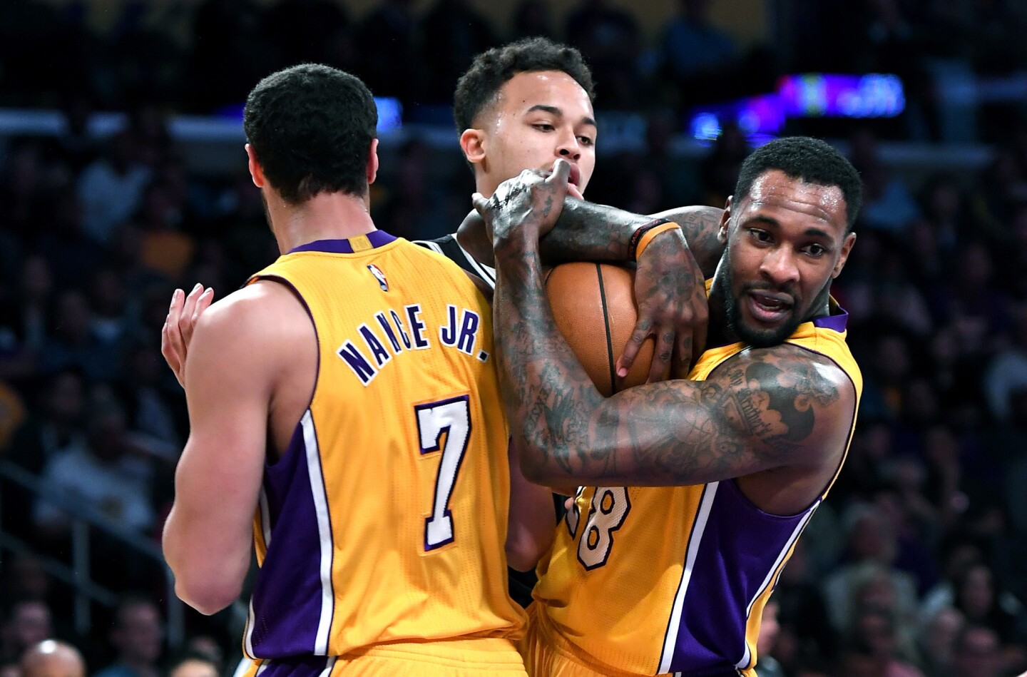 Lakers center Tarik Black grabs a rebound from teammate Larry Nance Jr. and Spurs guard Danny Green at Staples Center on Nov. 18.