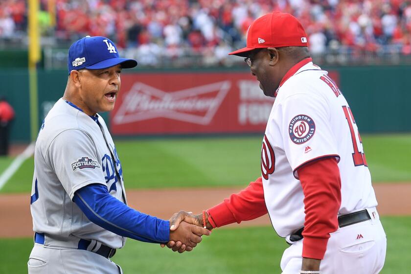 Dodgers Manager Dave Roberts and Nationals Manager Dusty Baker shake hands before Game 1 of the NLDS on Friday at Nationals Park.