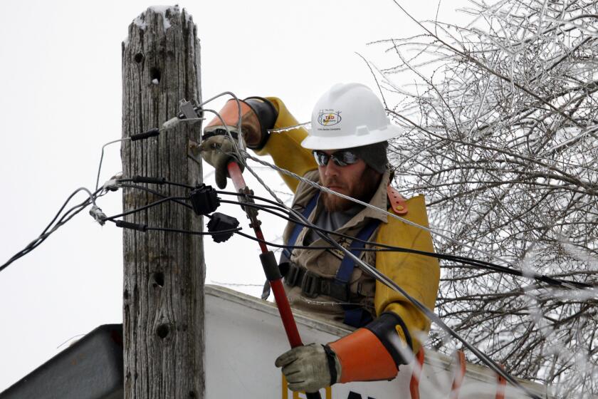 Cory Bean repairs a power line in East Lansing, Mich. Bean, part of a crew from a Kentucky utility service company, has been working in Michigan since Sunday to restore power after an ice storm.