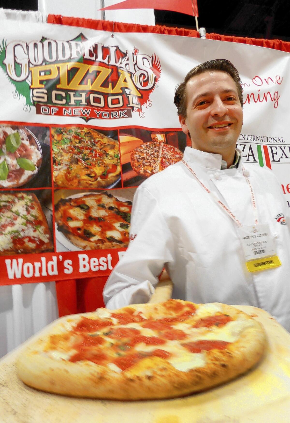 Andrew Scudera, a cook from Goodfellas Pizza School of New York, takes a fresh pie from the oven for the throngs to sample at the International Pizza Expo in Las Vegas.