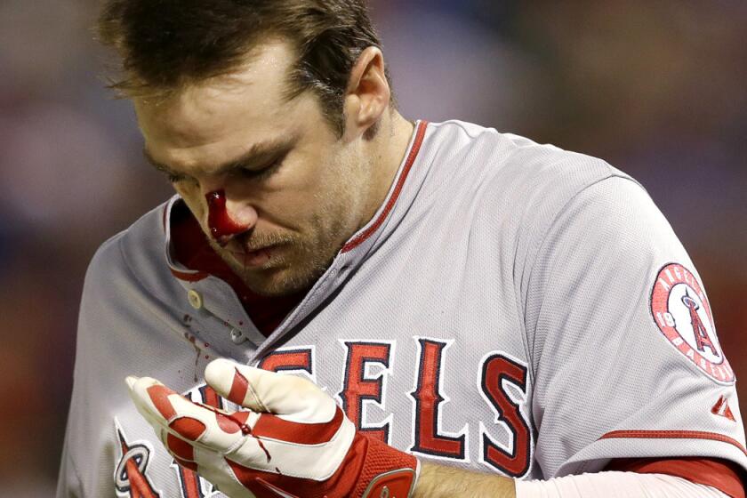 Blood gushes from the nose of Angels outfielder Collin Cowgill after he foul-tipped a pitch during the eighth inning of a game against the Rangers on Saturday night in Arlington, Texas.