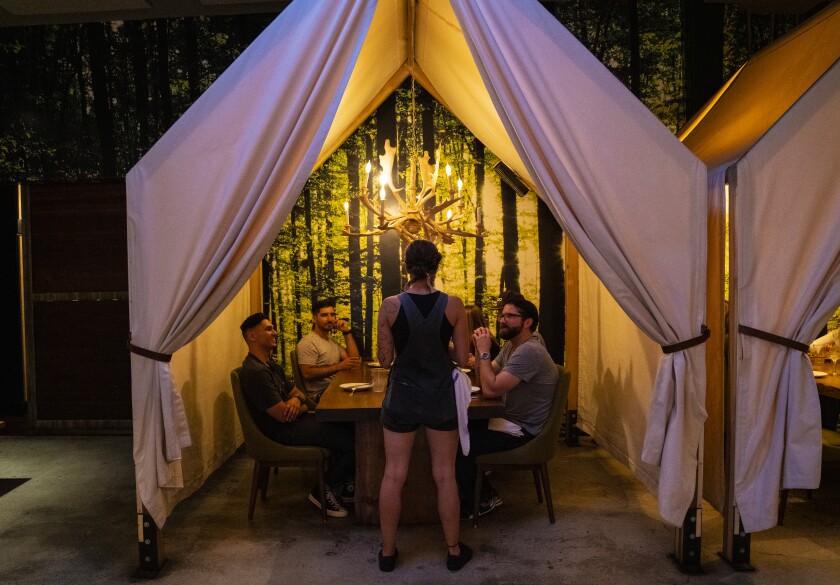 Kate Marckese-Jass at One Door North in North Park takes a drink order from a group of friends celebrating their first dinner outing together since the coronavirus pandemic