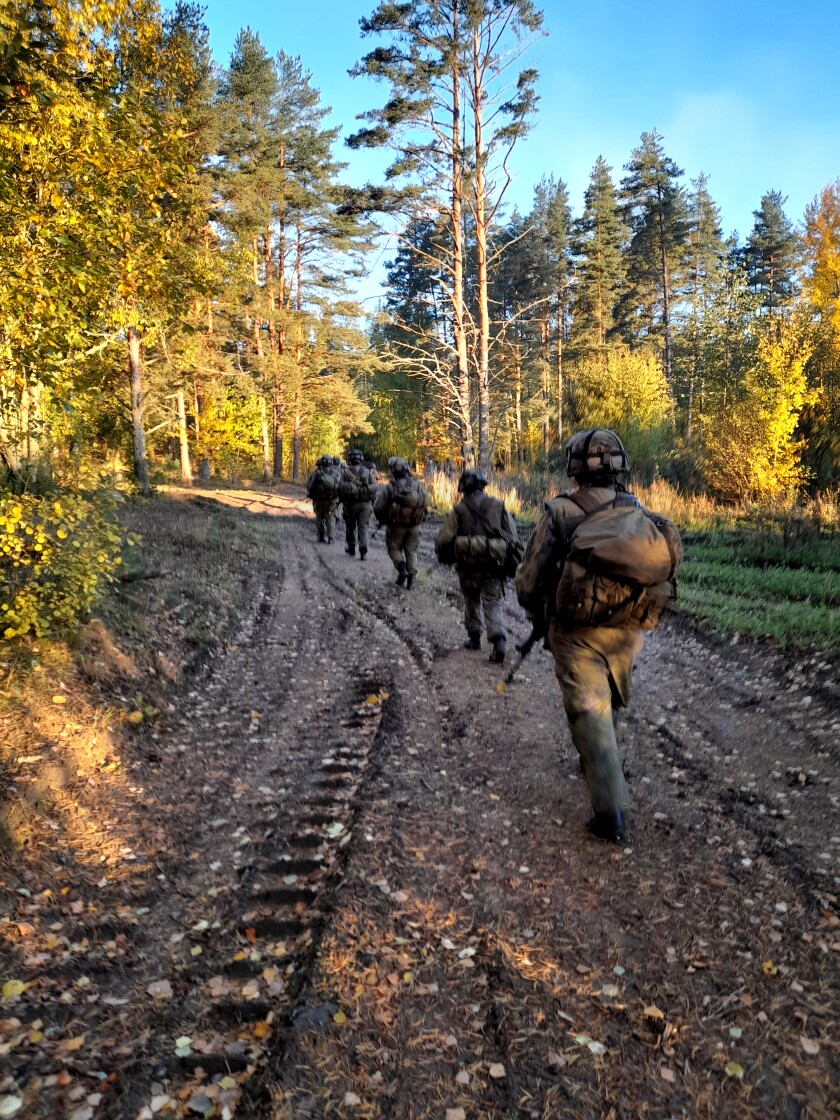 Soldiers with packs and rifles.