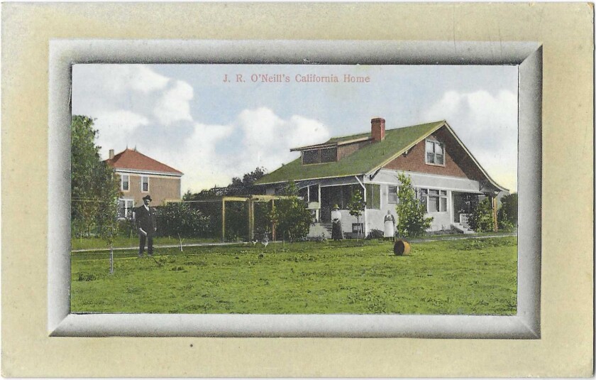 A man and two women stand in front of a home bordered by a lawn.