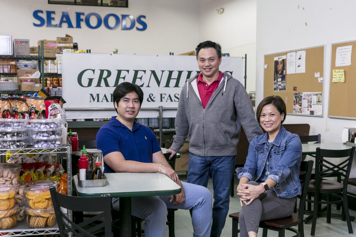 Greenhills Market & Fast Food co-owners Larry Lim, center, and Angela Lim, right, with store manager Patrick Tan.