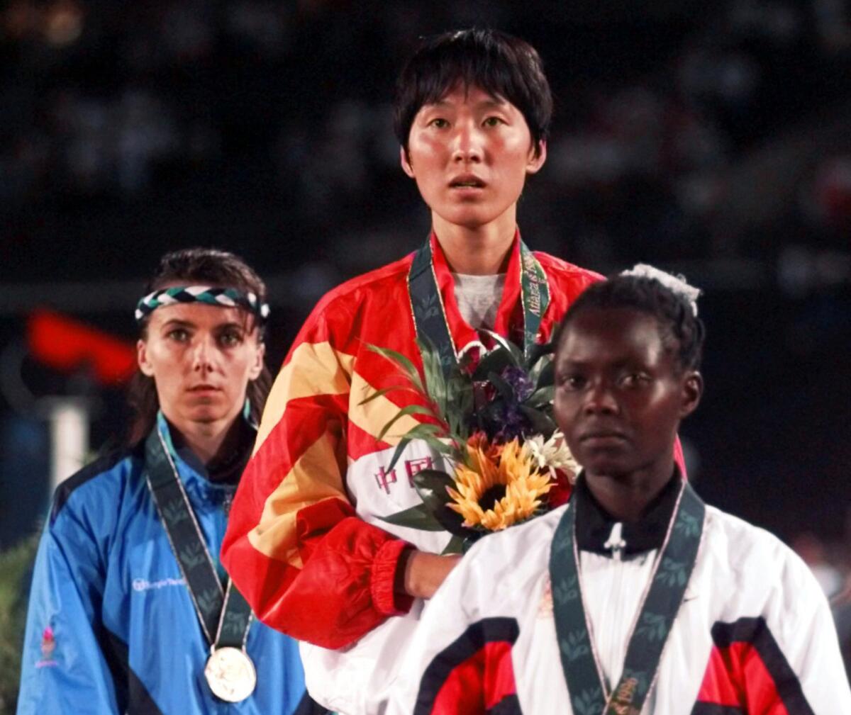 Women's 5,000-meter gold medalist Wang Junxia of China, center, is flanked by Kenya's Pauline Konga, right, and Italy's Roberta Brunet at the Atlanta Olympics on July 28, 1996.