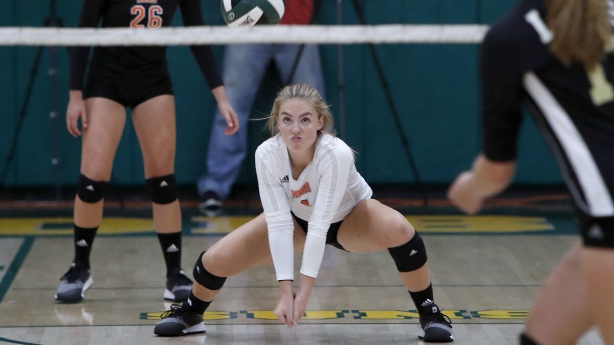 Huntington Beach High's Mia Christensen gets low for a dig against JSerra in the second set of a nonleague match on Aug. 29, 2018.