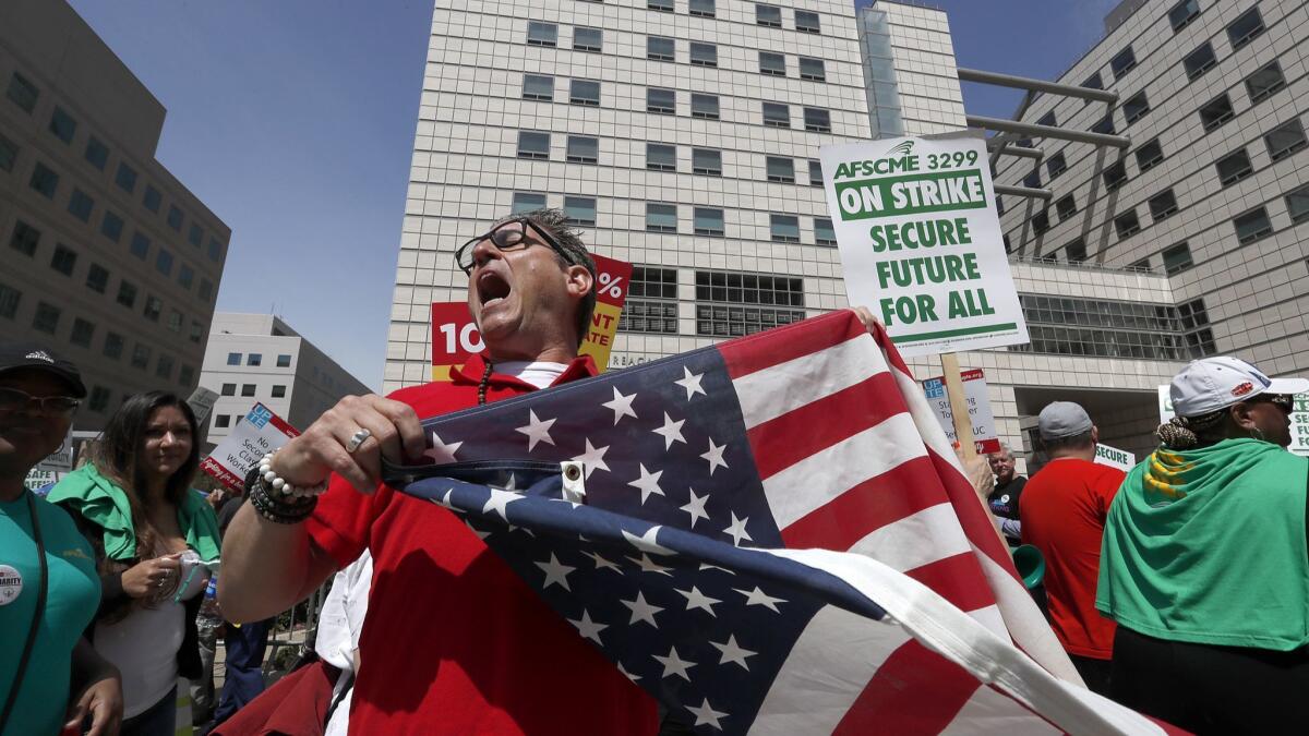 Nurse Kevin-Marc Ramos joins fellow labor union members in a protest outsuide the Ronald Reagan Medical Center at UCLA.