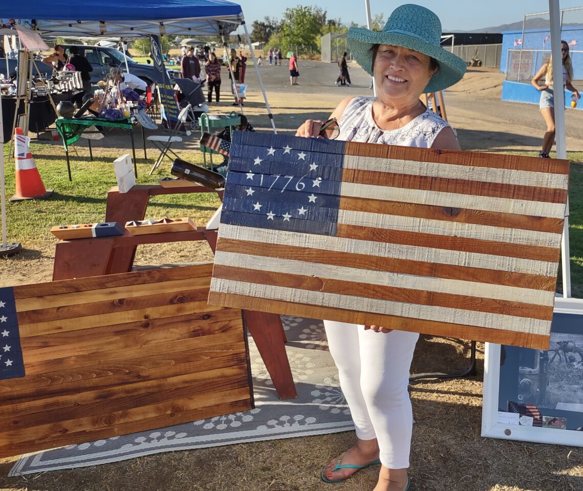 Cheryl Van Dyne displays one of the American flags she made with her husband George that they were selling at the event.