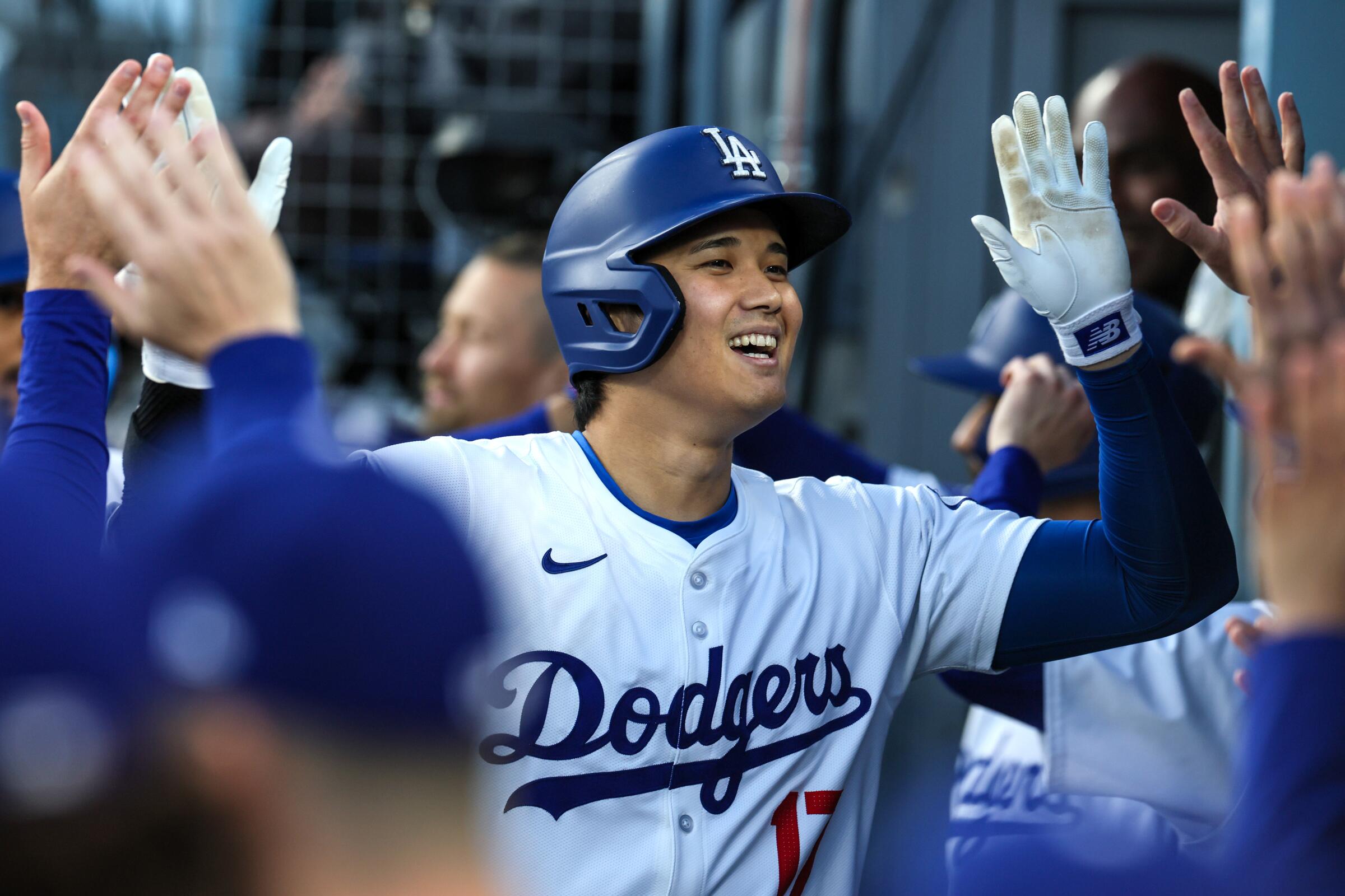 Dodgers designated hitter Shohei Ohtani celebrates in the dugout after hitting a two-run home run against the Miami Marlins.