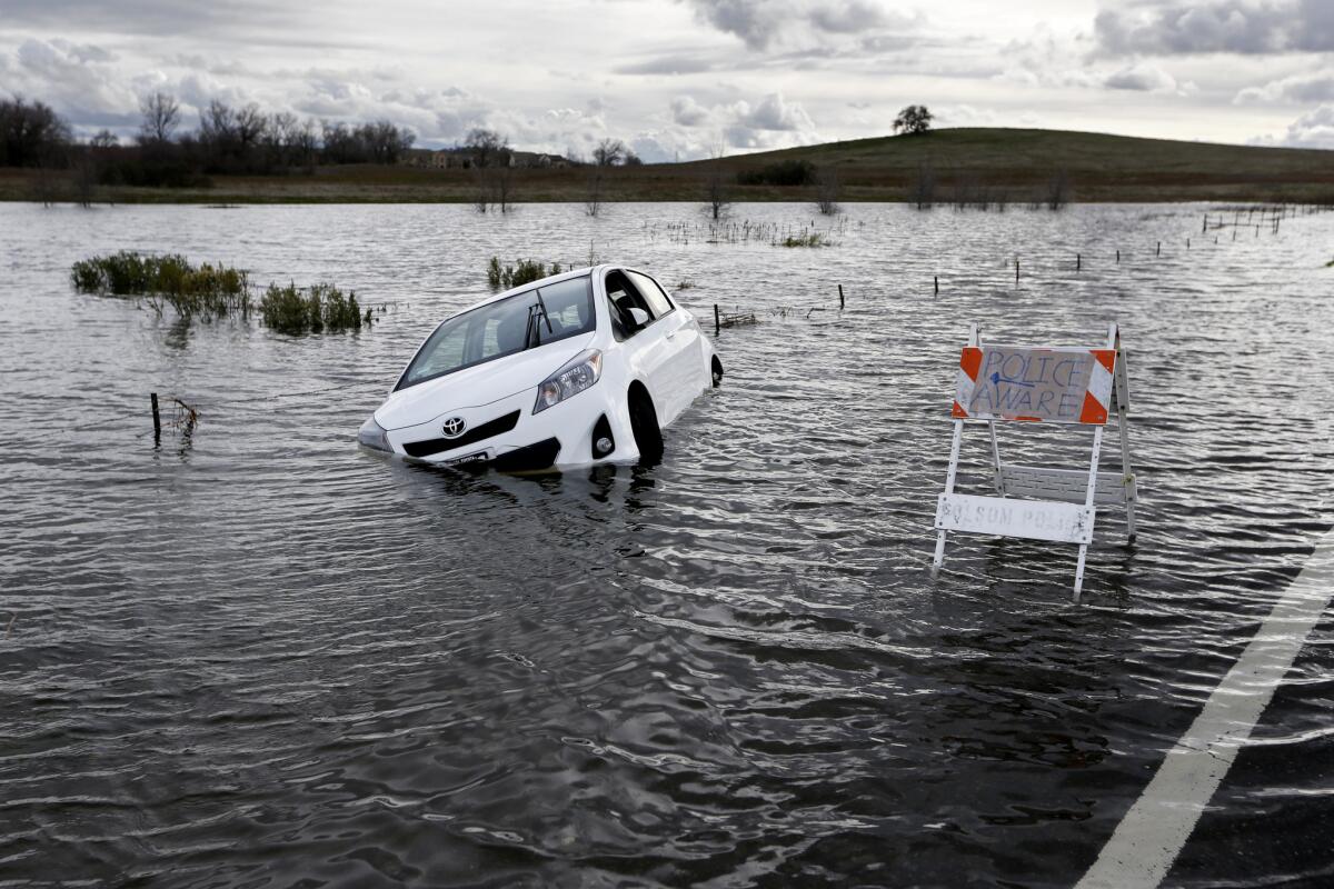 A Toyota automobile is submerged along Green Valley Road near Folsom Dam in Folsom, Calif., on Jan. 11, 2017.
