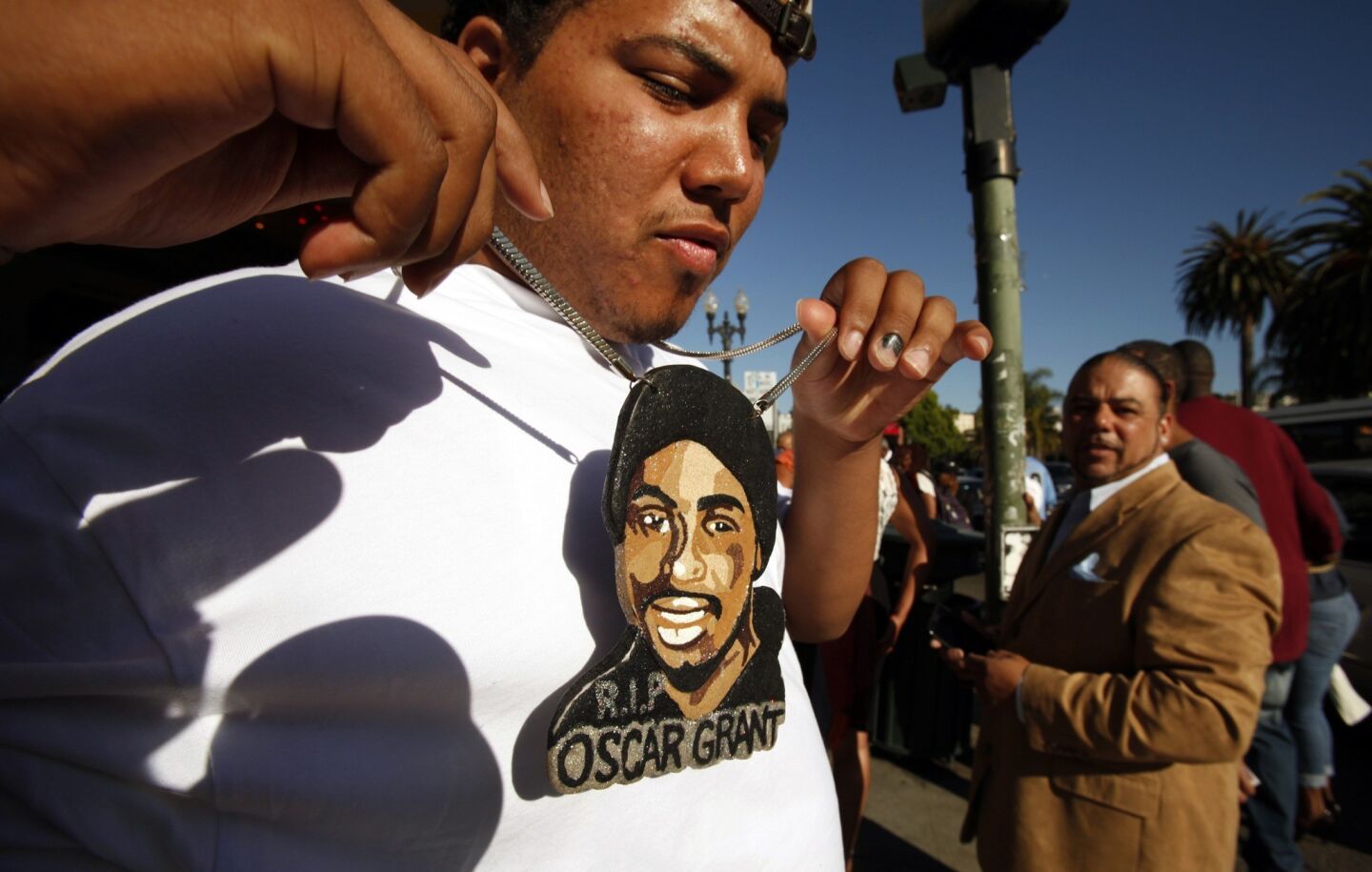 Nigel Bryson, 23, who had been riding the train with Oscar Grant the night he was killed in 2009, wears a large pendant painted with Grant's face on it to the Oakland premiere of "Fruitvale Station" at the Grand Lake Theatre on June 20, 2013.