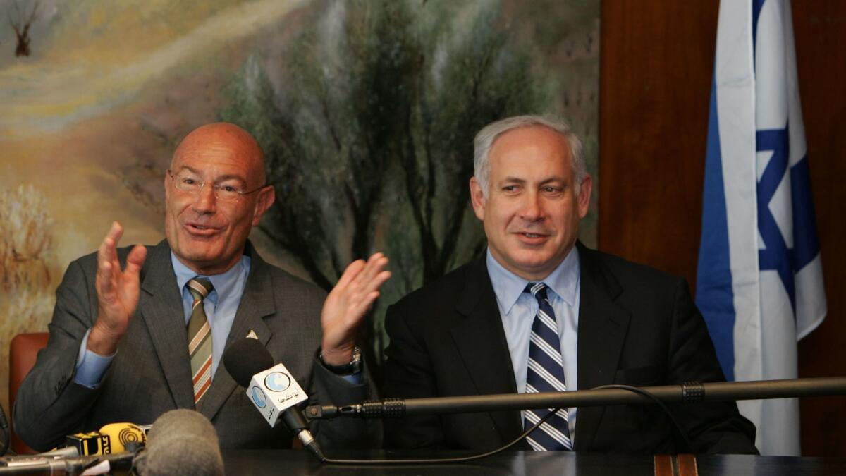 Israeli-American movie producer Arnon Milchan, left, is flanked by then-Finance Minister Benjamin Netanyahu as he announces his donation of $100 million to establish a new Israeli university, at a news conference on March 28, 2005, in Jerusalem.