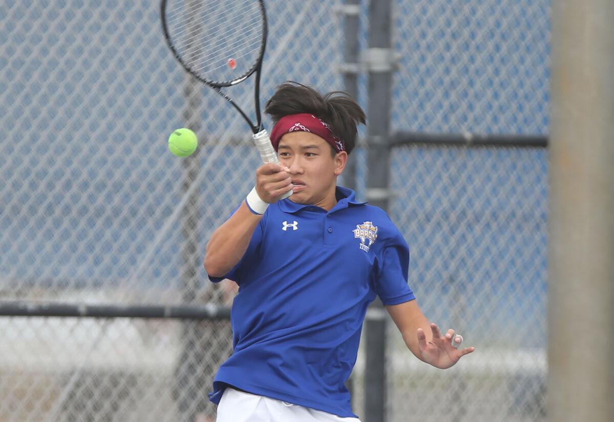 Fountain Valley singles player Alan Ton runs down a forehand during a nonleague match against Beckman at home Thursday.