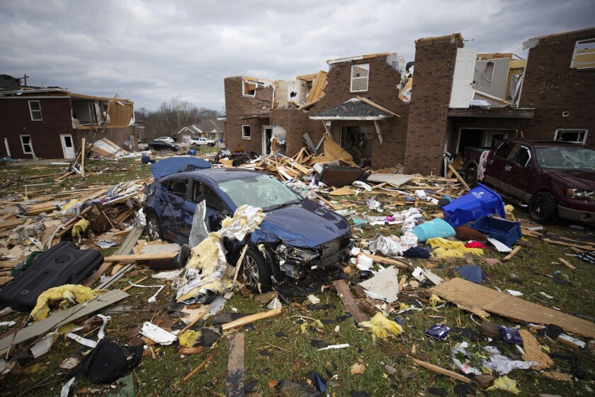 A car sits in the debris caused by a tornado in Bowling Green, Ky., Saturday, Dec. 11, 2021. A monstrous tornado killed dozens of people in Kentucky and the toll was climbing Saturday after severe weather ripped through at least five states, leaving widespread devastation. (AP Photo/Michael Clubb)