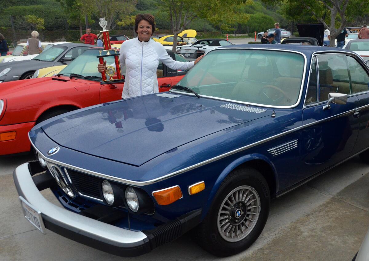 Denise Oglesby, poses with her Best Of Show Import trophy for her 1974 3.0 BMW at the OASIS car show.