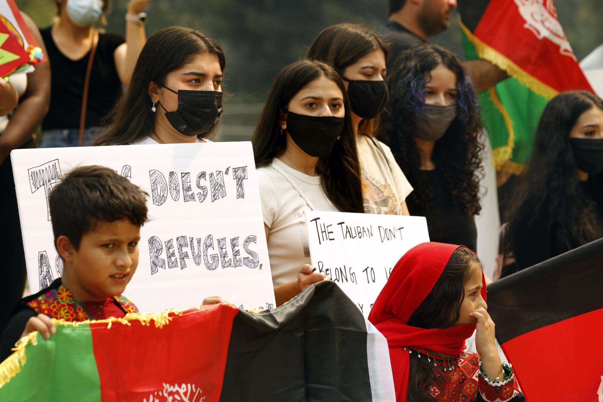 People hold signs and flags during a protest at the Capitol in Sacramento