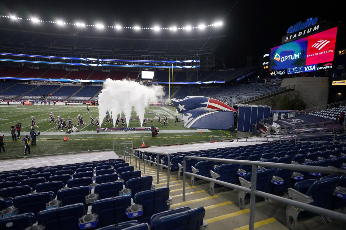 The New England Patriots run on to the field in an empty Gillette Stadium for a game.