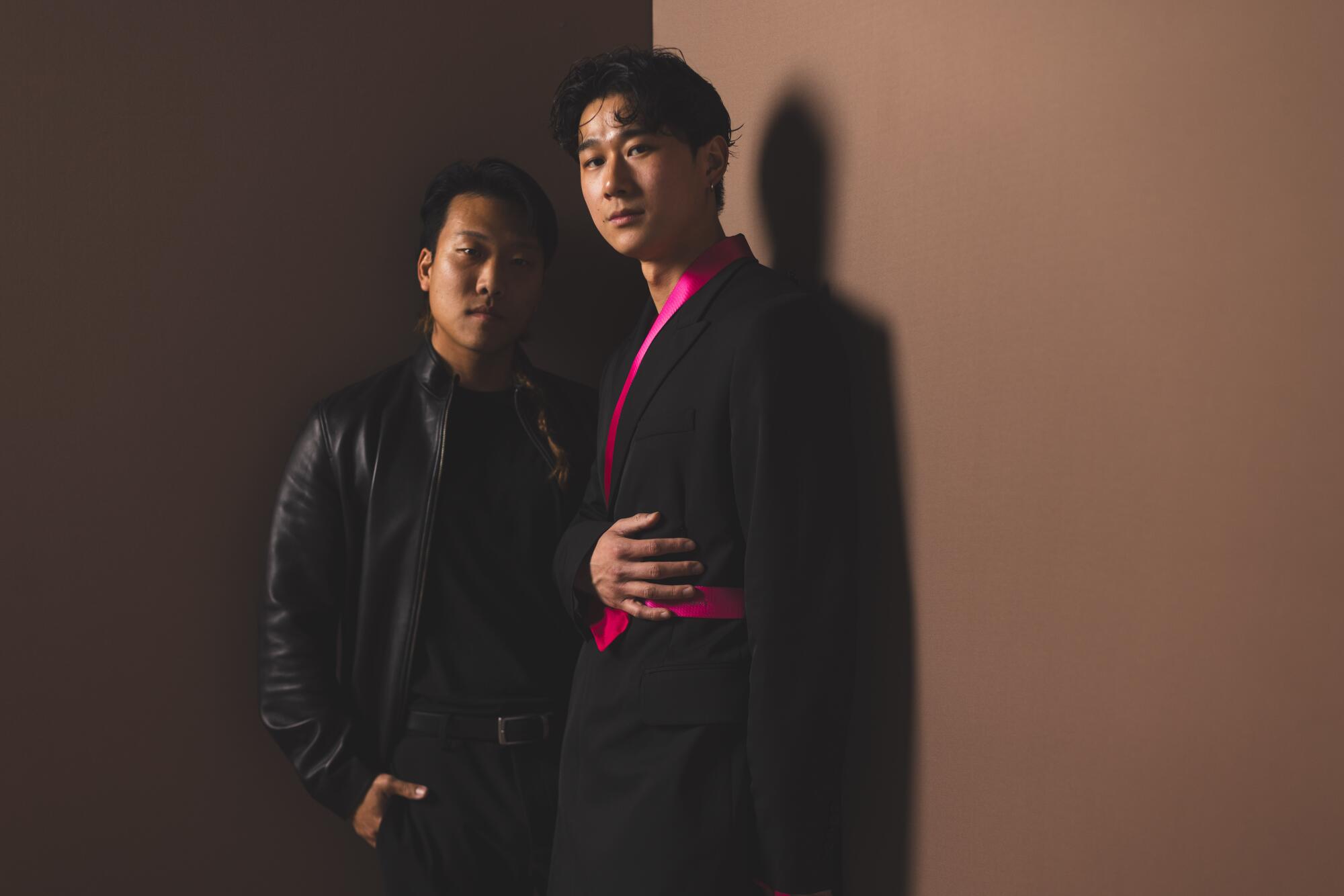 Joon Lee and Sam Song Li stand in a corner next to each other.