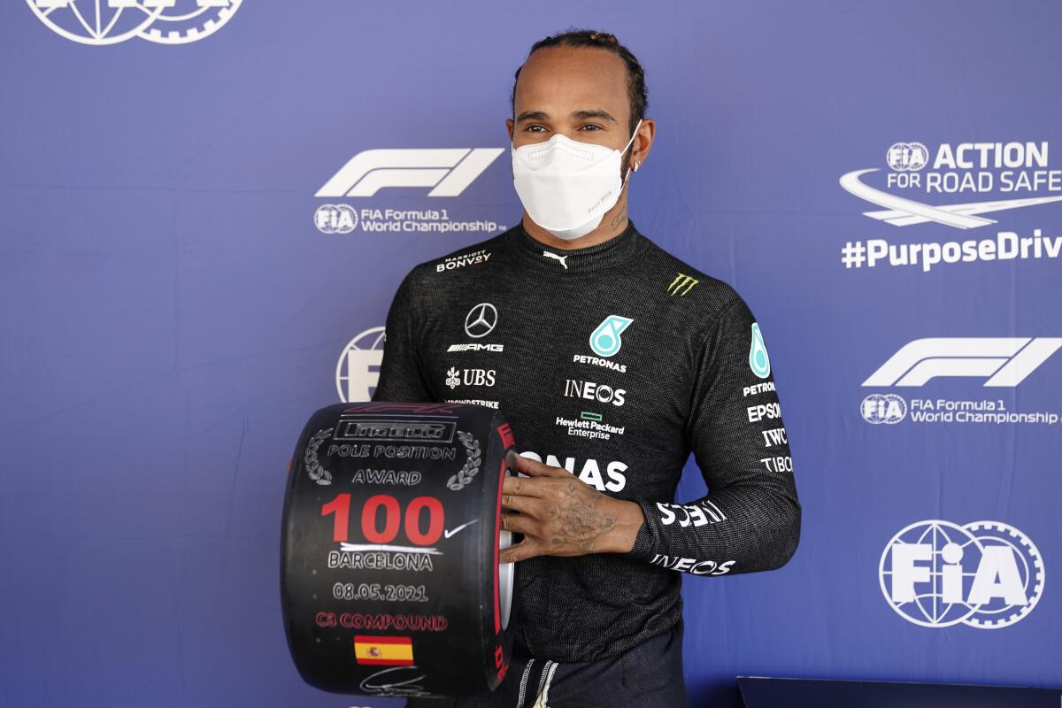 Mercedes driver Lewis Hamilton of Britain poses with a wheel-shaped award.