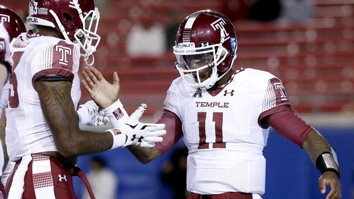 Temple quarterback P.J. Walker (11) is congratulated by running back Zaire Williams after running for a touchdown against SMU on Friday night in Dallas.
