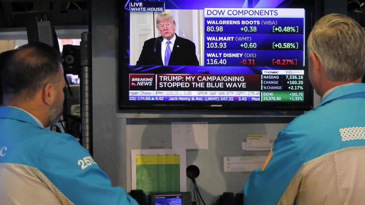 Specialists on the floor of the New York Stock Exchange watch President Trump's news conference on Wednesday. The market's broad gains follow election results that came in largely as investors had expected.