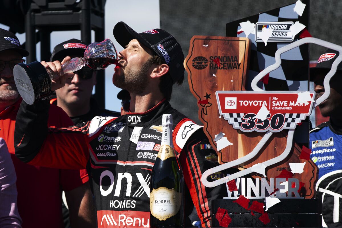 Daniel Suarez drinks some of the wine from the winner's goblet after a NASCAR Cup Series race, Sunday, June 12, 2022, at Sonoma Raceway in Sonoma, Calif. (AP Photo/D. Ross Cameron)