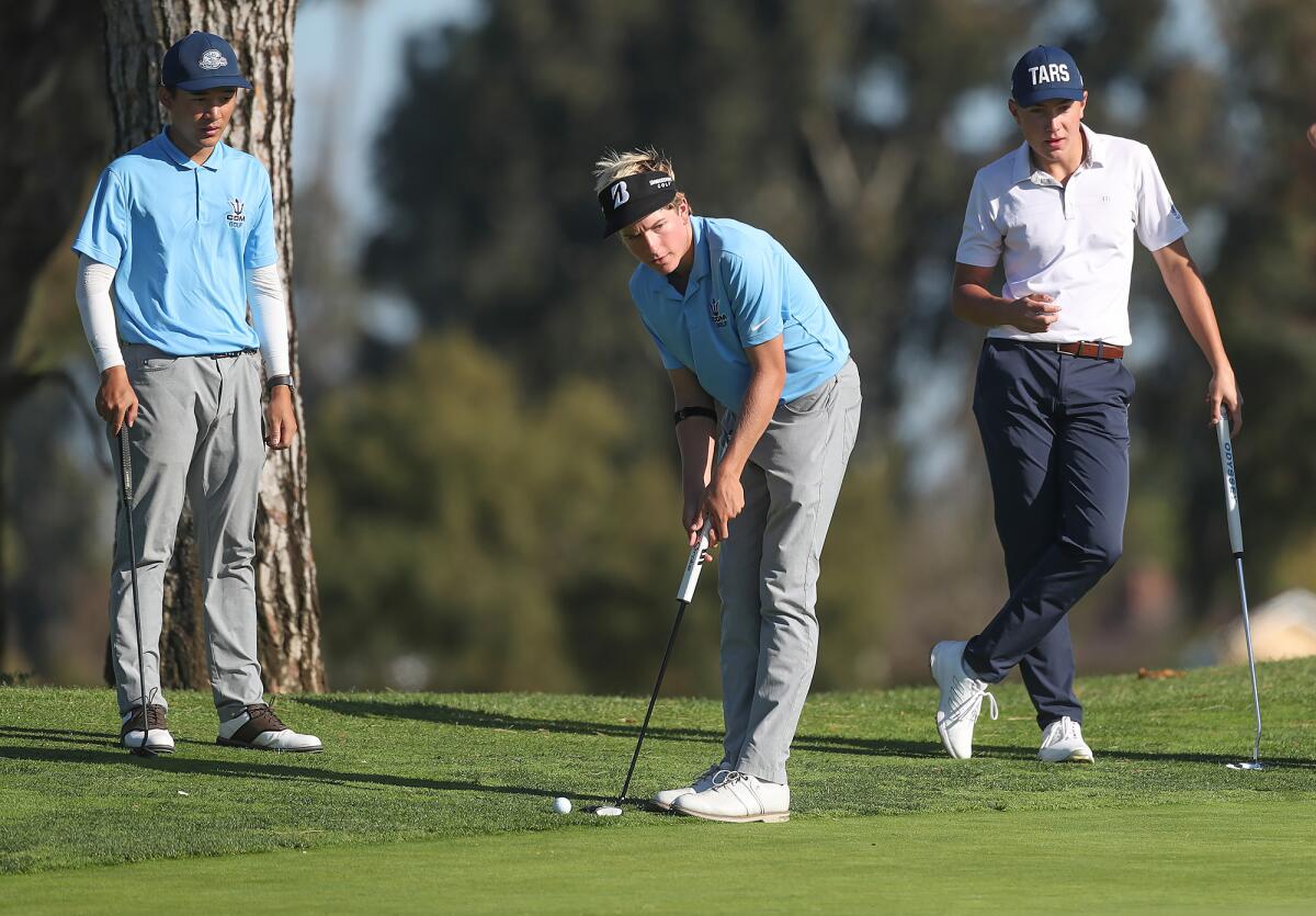 CdM's Charlie Olson lines up a putt as partner Steven Yang, left, and opponent Zack Moreau, right, of Newport Harbor look on.