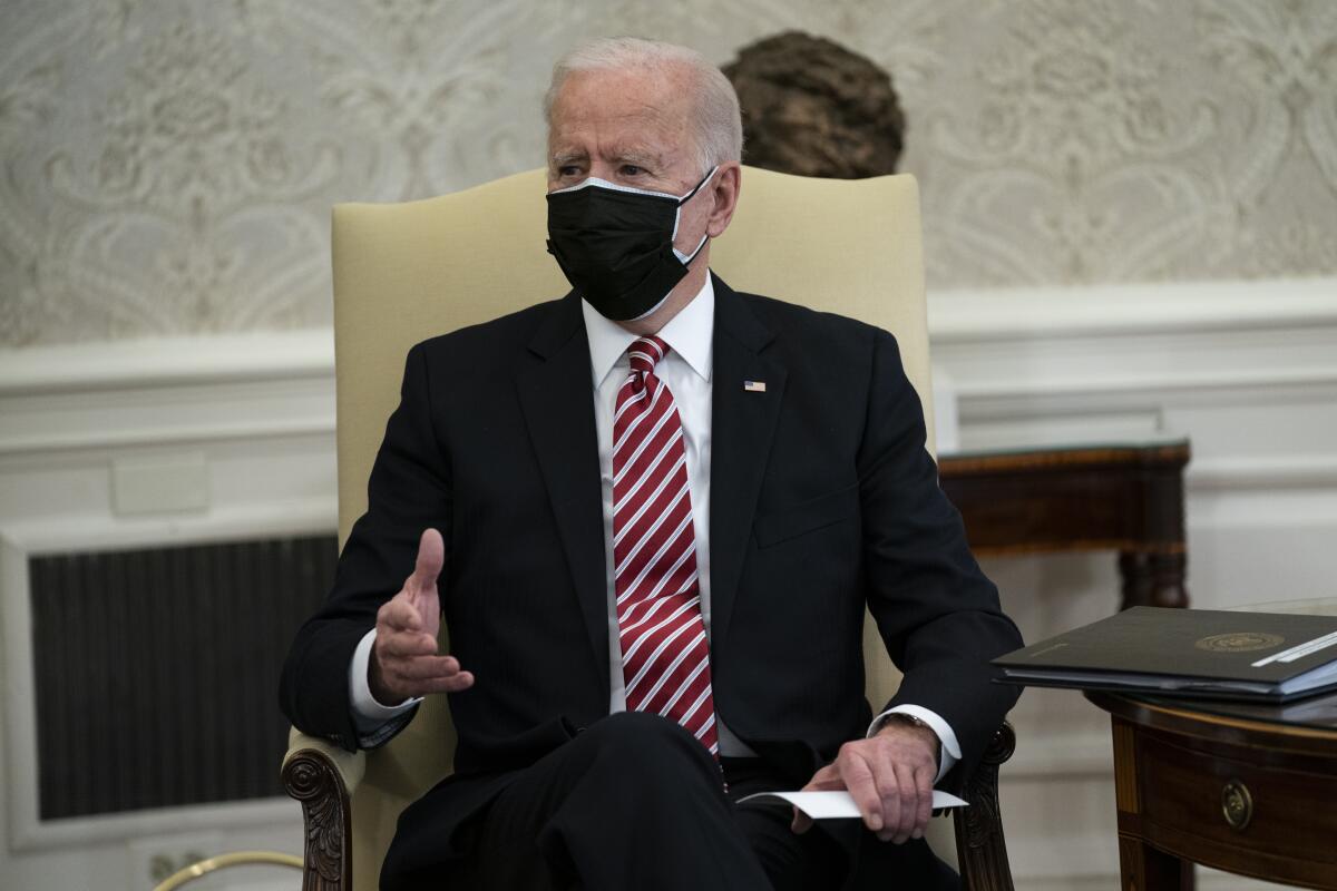 President Biden speaks, wearing a mask