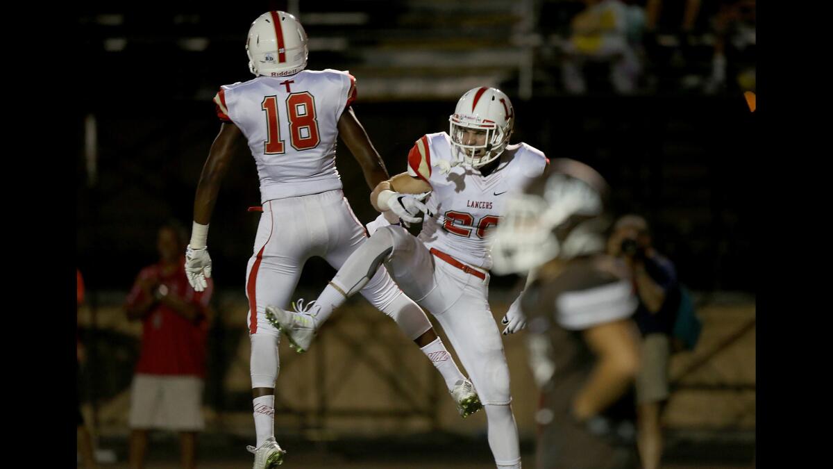 Orange Lutheran wide receiver Austin Liles celebrates with teammate Milson Lathan after scoring a touchdown on a long pass play against Crespi in the second quarter Friday night.