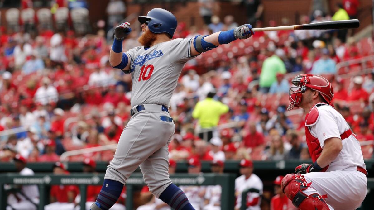 Dodgers' Justin Turner (10) and St. Louis Cardinals catcher Matt Wieters watch a sacrifice fly by Turner to score Joc Pederson during the first inning on April 11, 2019, in St. Louis.