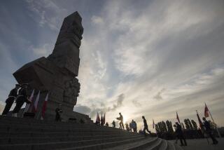 People lay a wreath at the monument to the 1939 heroic defense of the Westerplatte peninsula outpost during solemn observances of the 85th anniversary of the outbreak of World War II, at Westerplatte, on the Baltic Sea, Poland, on Sunday, Sept. 1, 2024. Attacked by a German Nazi warship in the small hours on Sept. 1, 1939, the Westerplatte military outpost was supposed to hold out for 24 hours, but its soldiers put up resistance to the Germans for seven days. (AP Photo/Wojciech Strozyk)